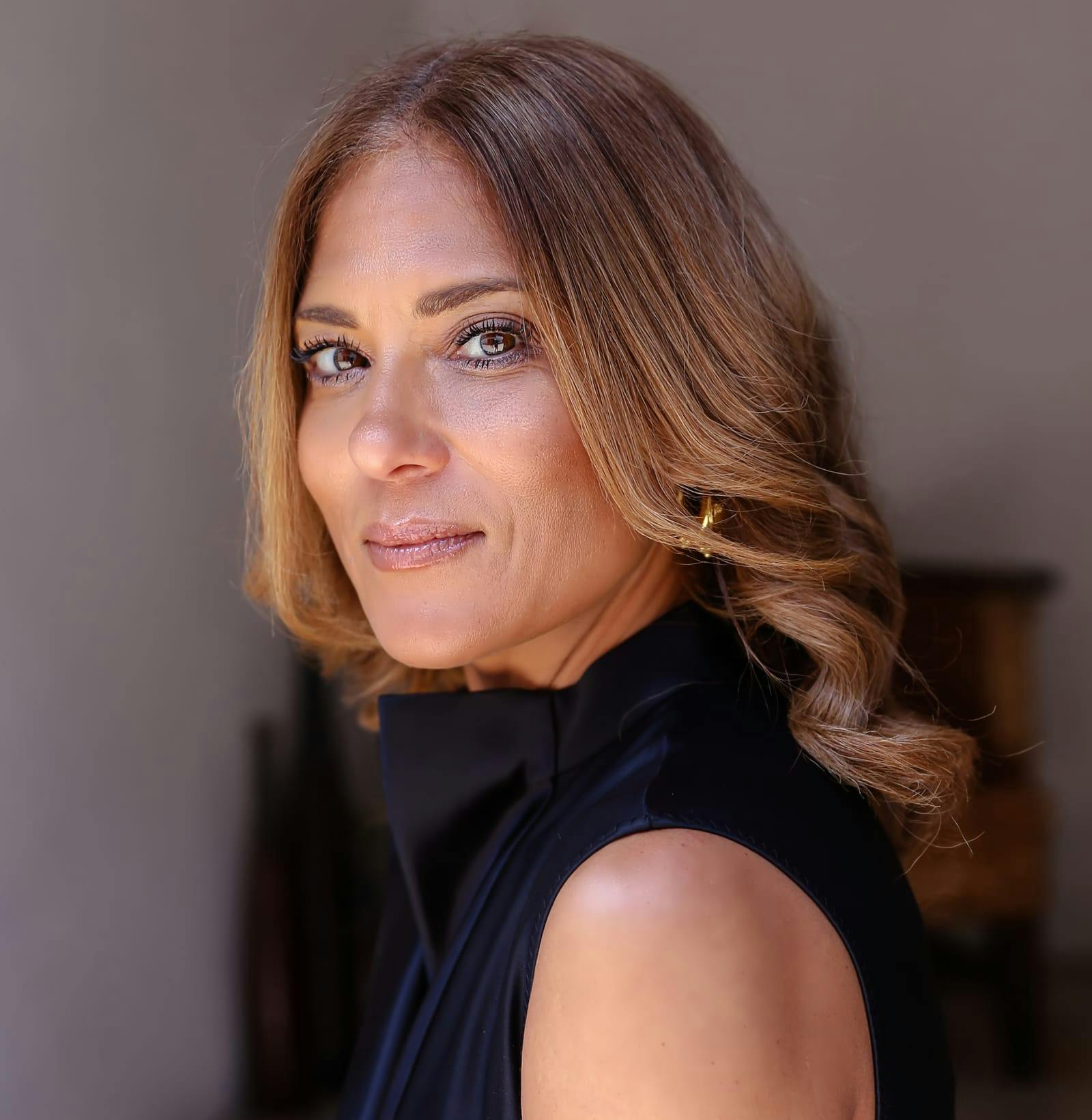 side profile of woman in black blouse with curled hair