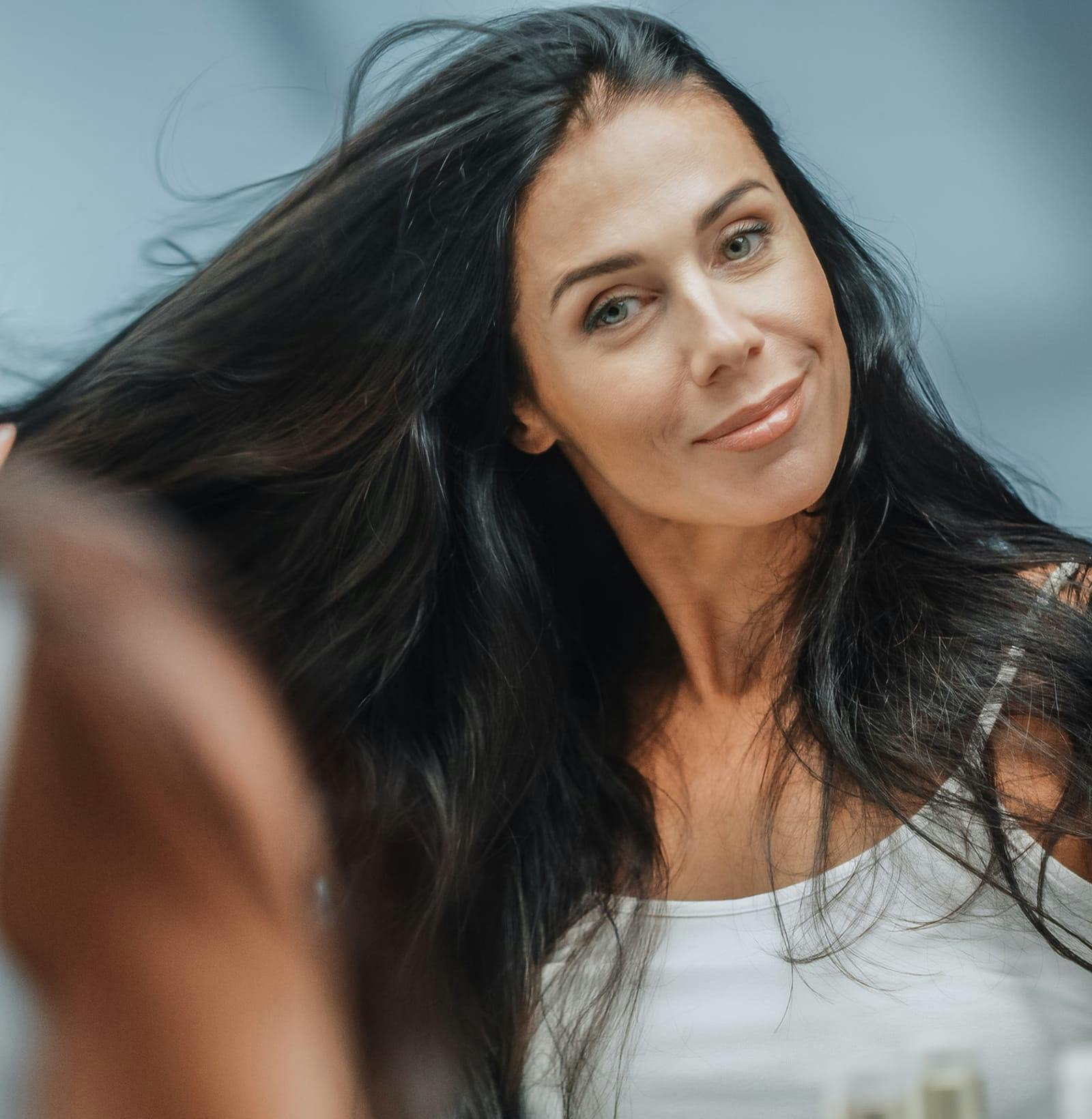 woman hand combing her long dark hair