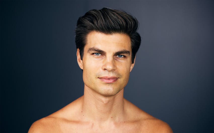 man with his arms crossed in front of his chest in blue long sleeve shirt