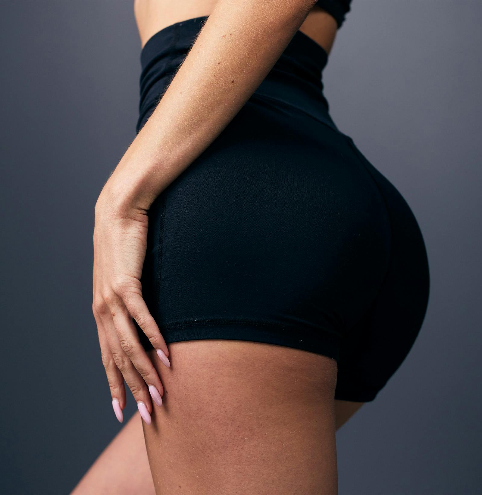 backside of a woman with her hand on bottom of her glute