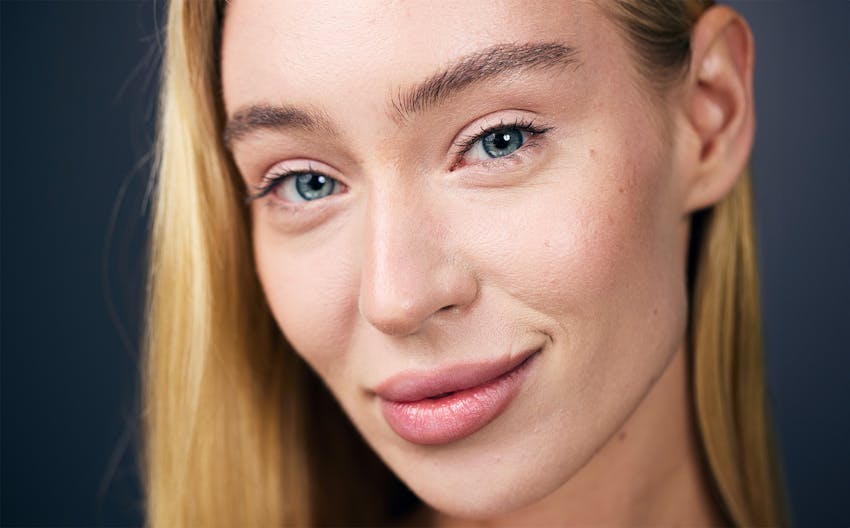 close up of blond woman's face with hair tucked behind ear