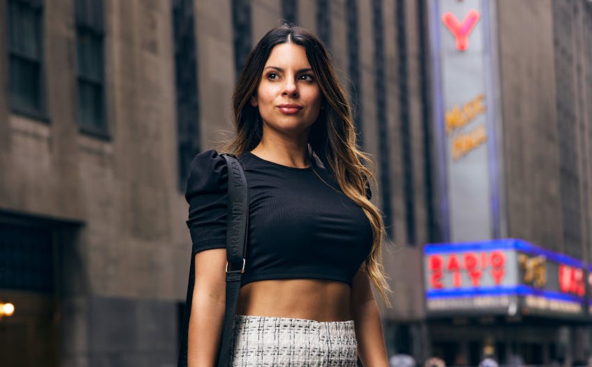 woman in street wearing black crop and patterned skirt