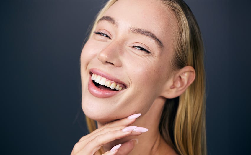 woman laughing with her hand resting on her chin
