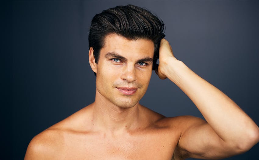 close up of man's face with his hand touching side of his head