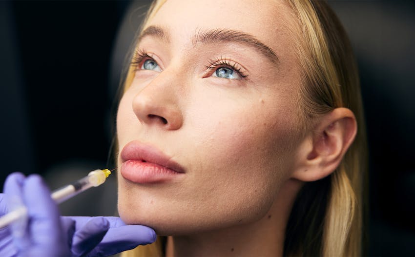 woman receiving an injectable treatment to her lips
