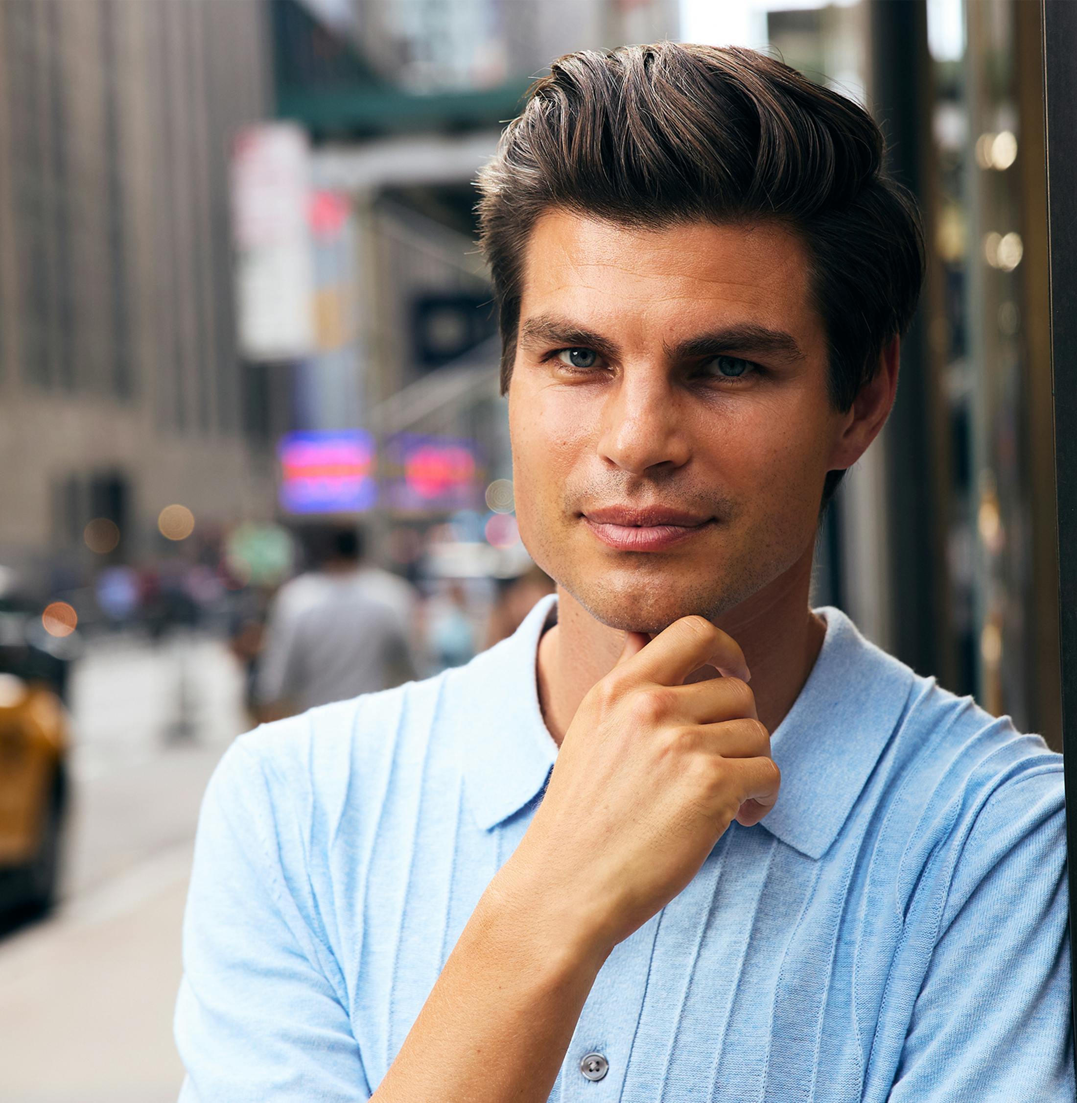man standing in street in blue collared shirt