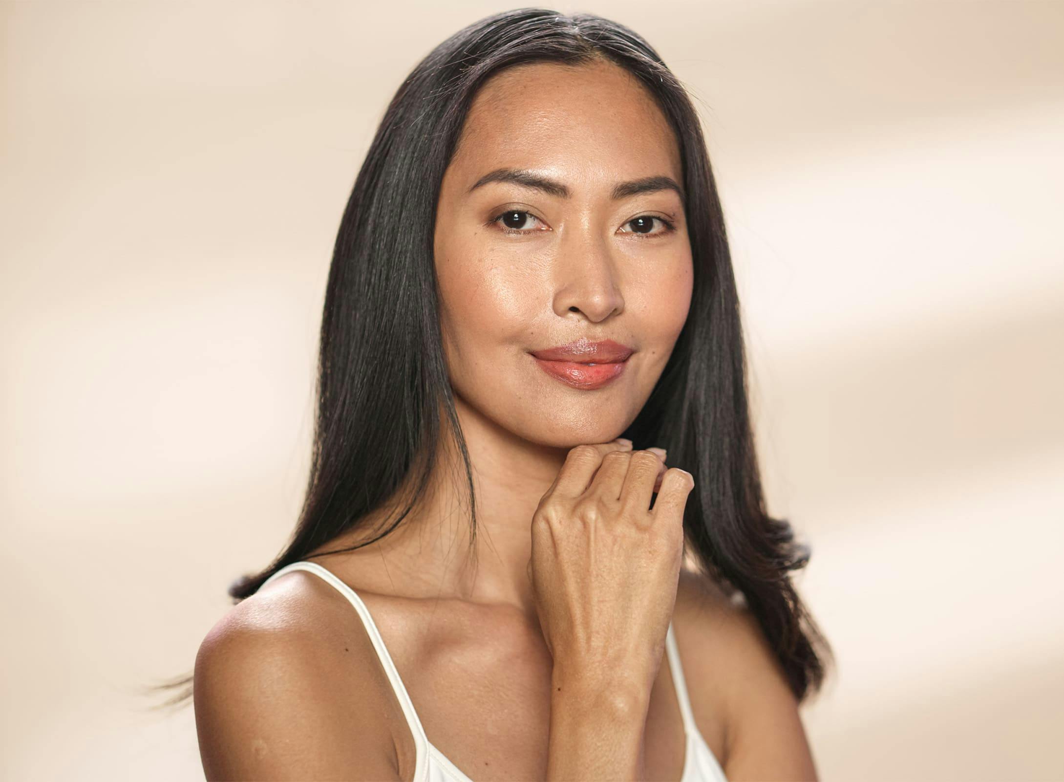 woman grinning with her hand under her chin