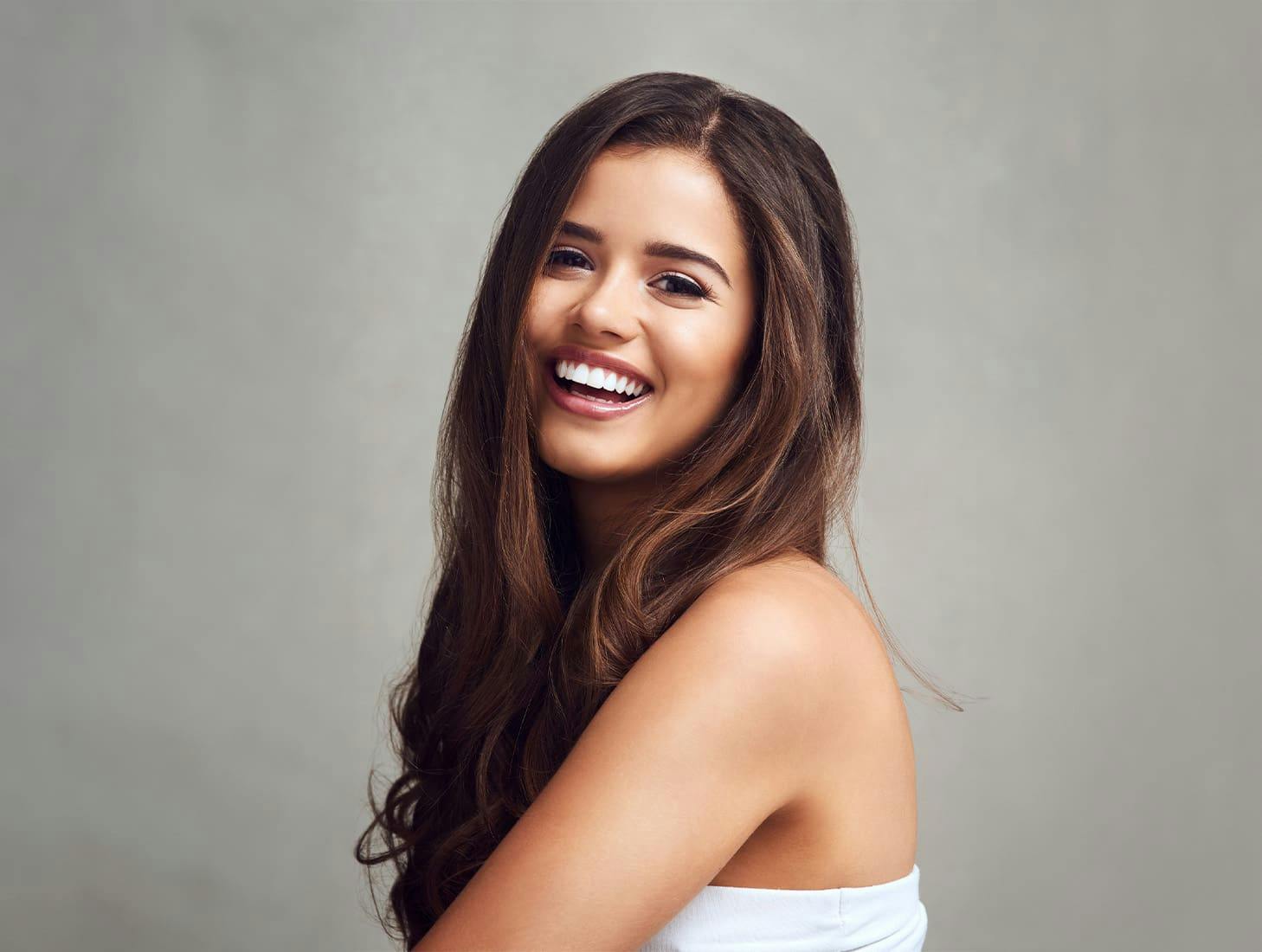 woman with wavy brunette hair smiling