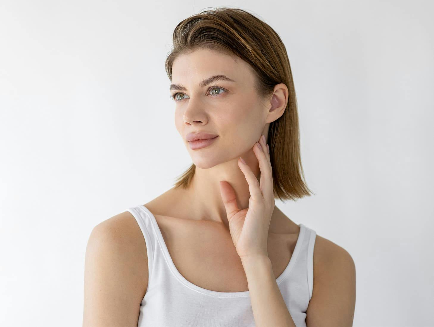 woman looking to the left with her fingers touching her jaw