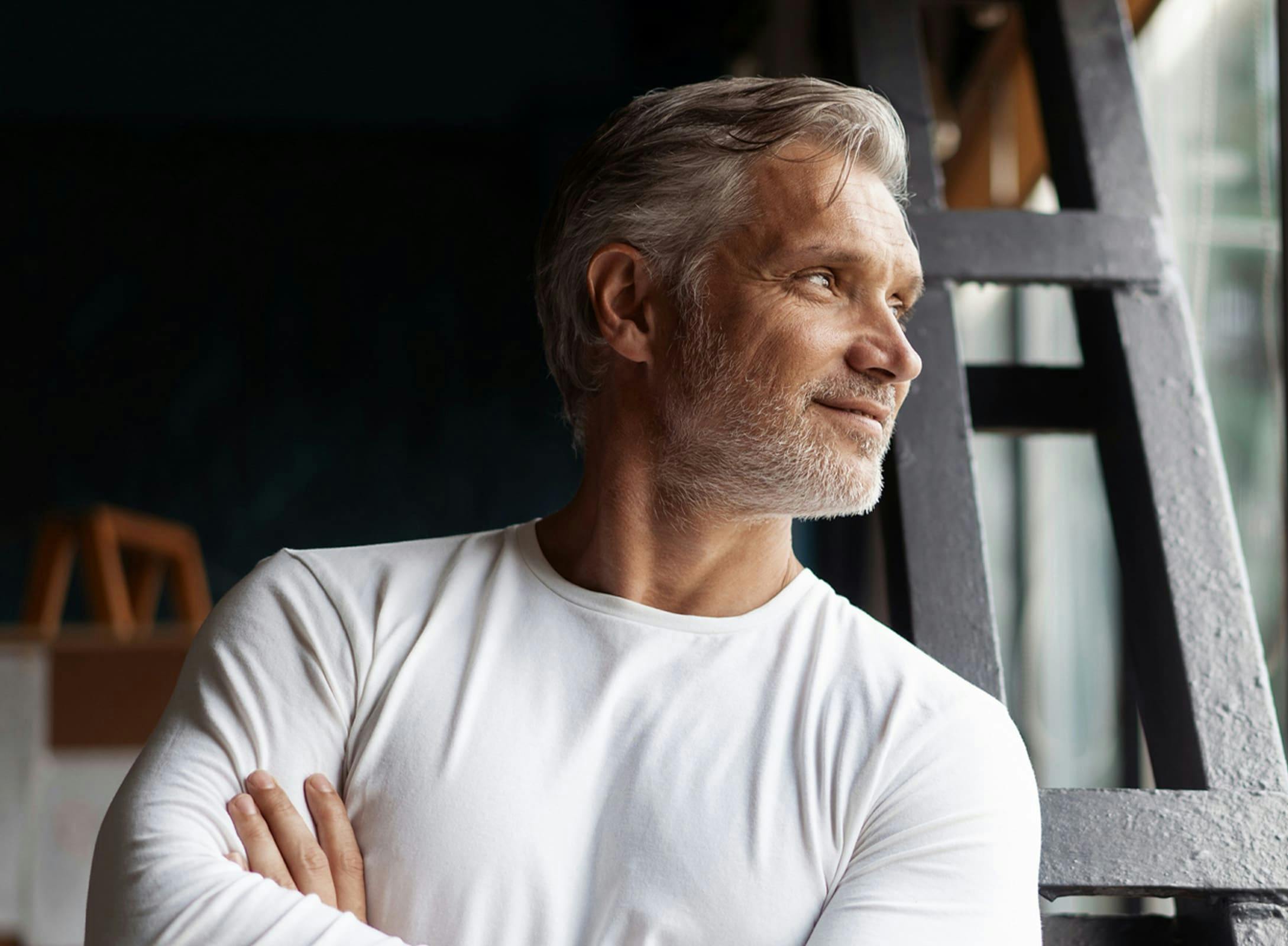 man looking out the window with her arms crossed