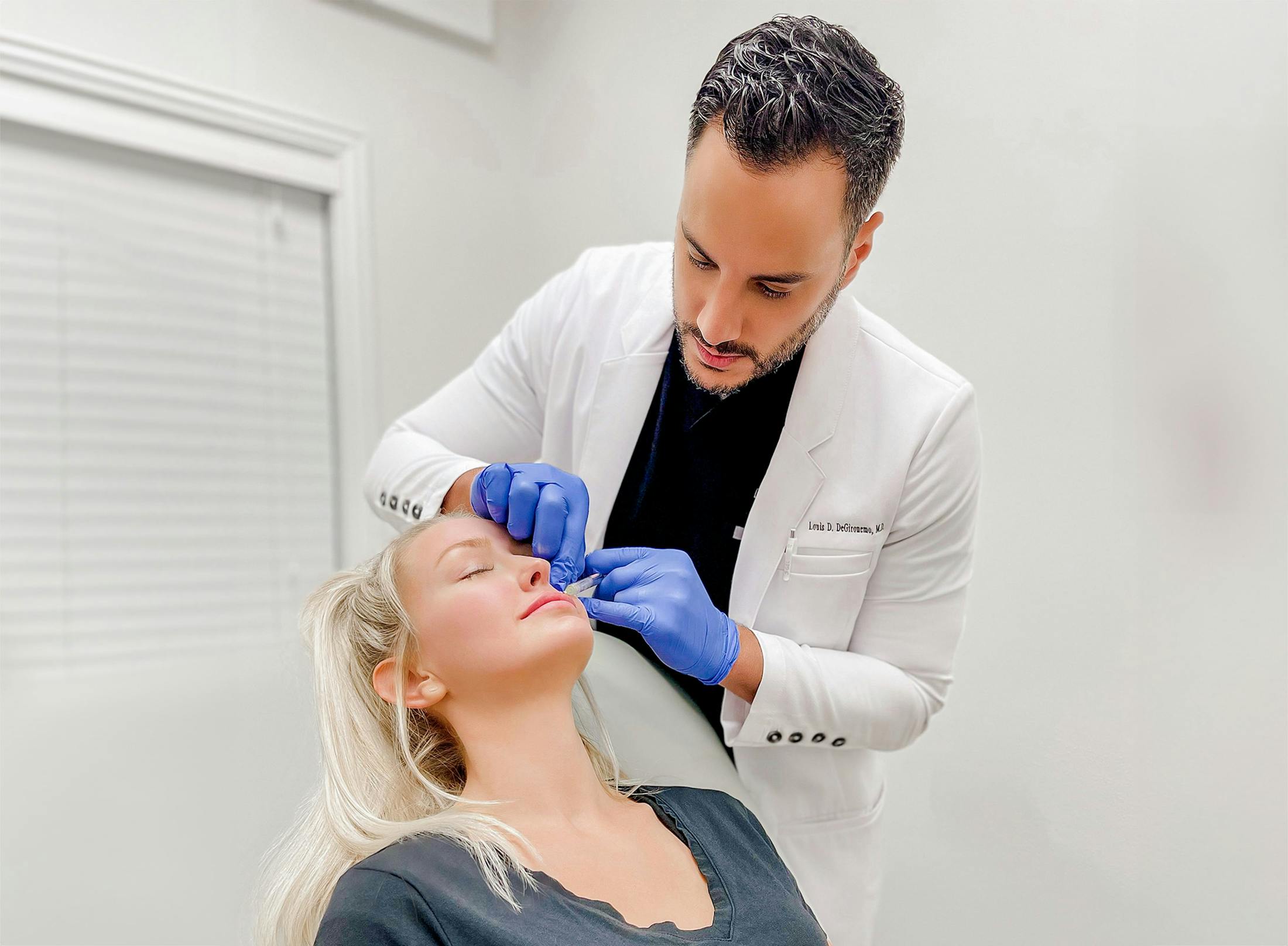 Dr. Louis Degironemo examining patient's skin