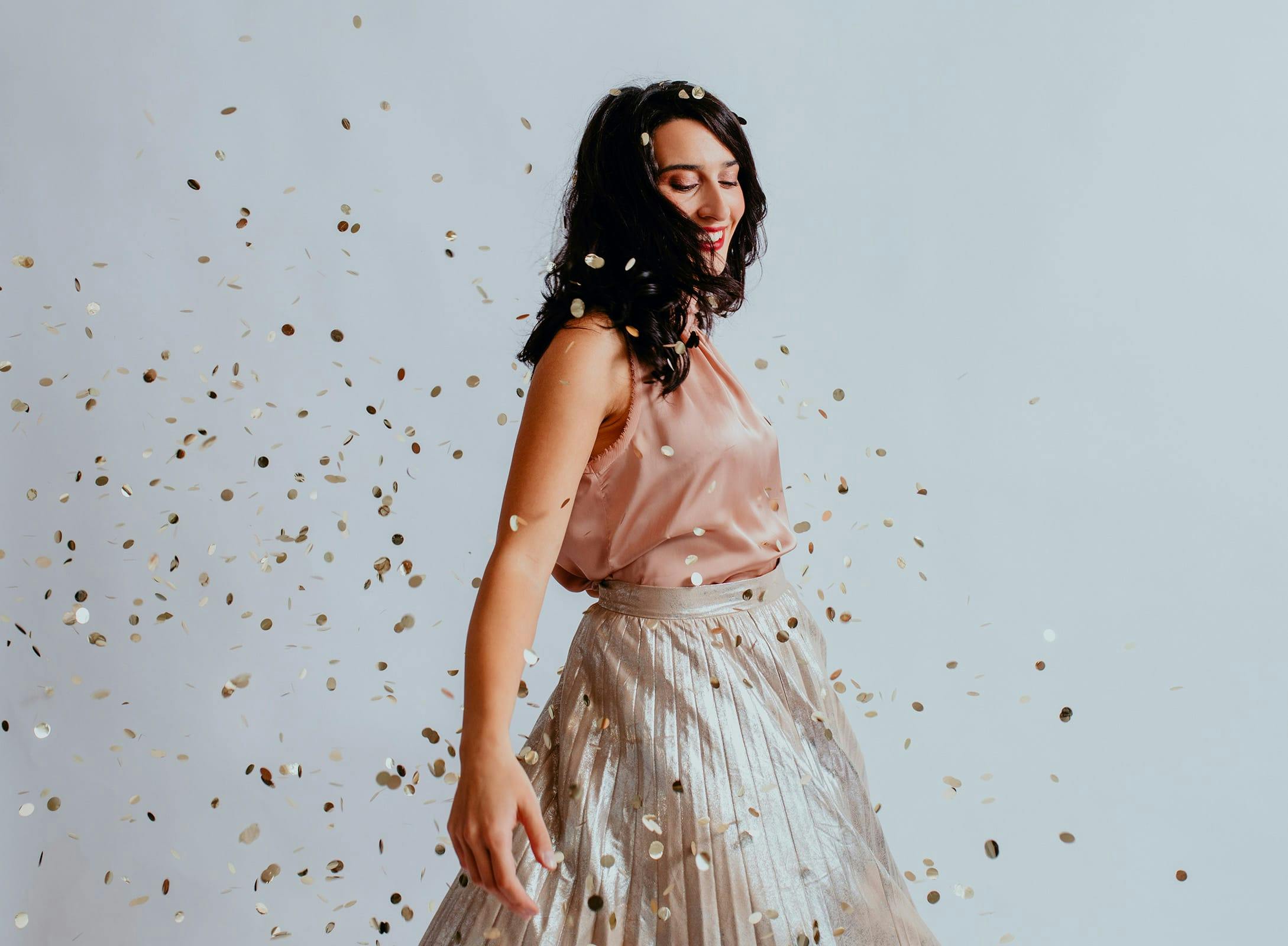 woman dancing in a cloud of confetti