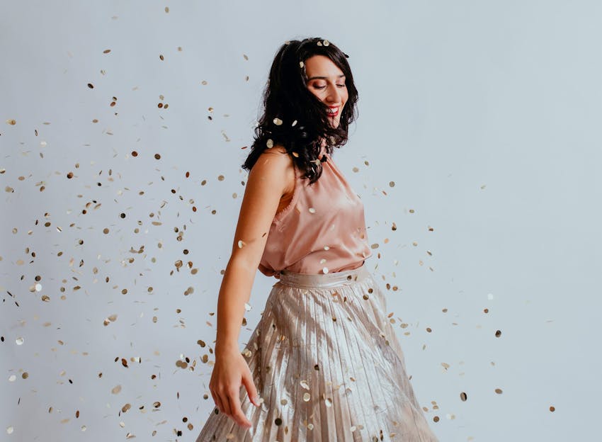 woman dancing in a cloud of confetti