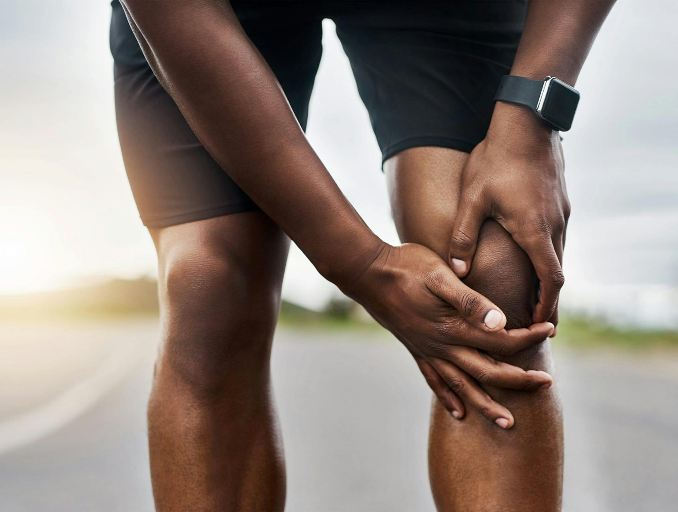 person touching their knee in discomfort