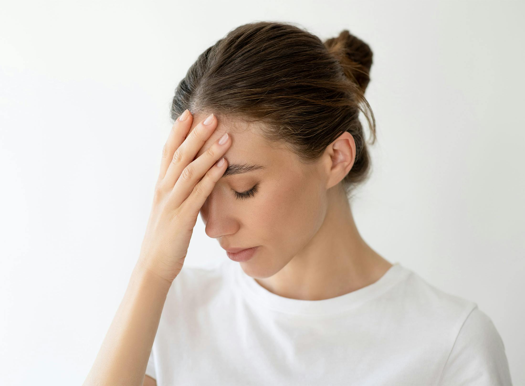 woman touching her head in discomfort