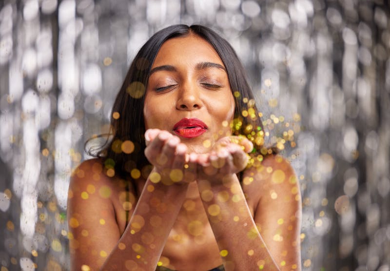 Woman, blow gold glitter and celebration with party and sparkle