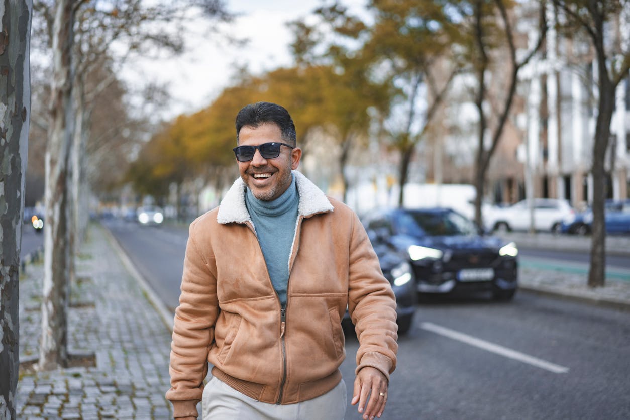 man wlaking in a tan jacket