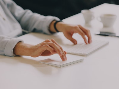 Person working on keyboard and touchpad
