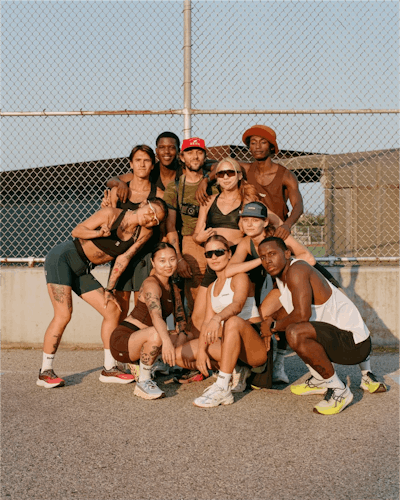 Group portrait of runners in front of a wire mesh fence