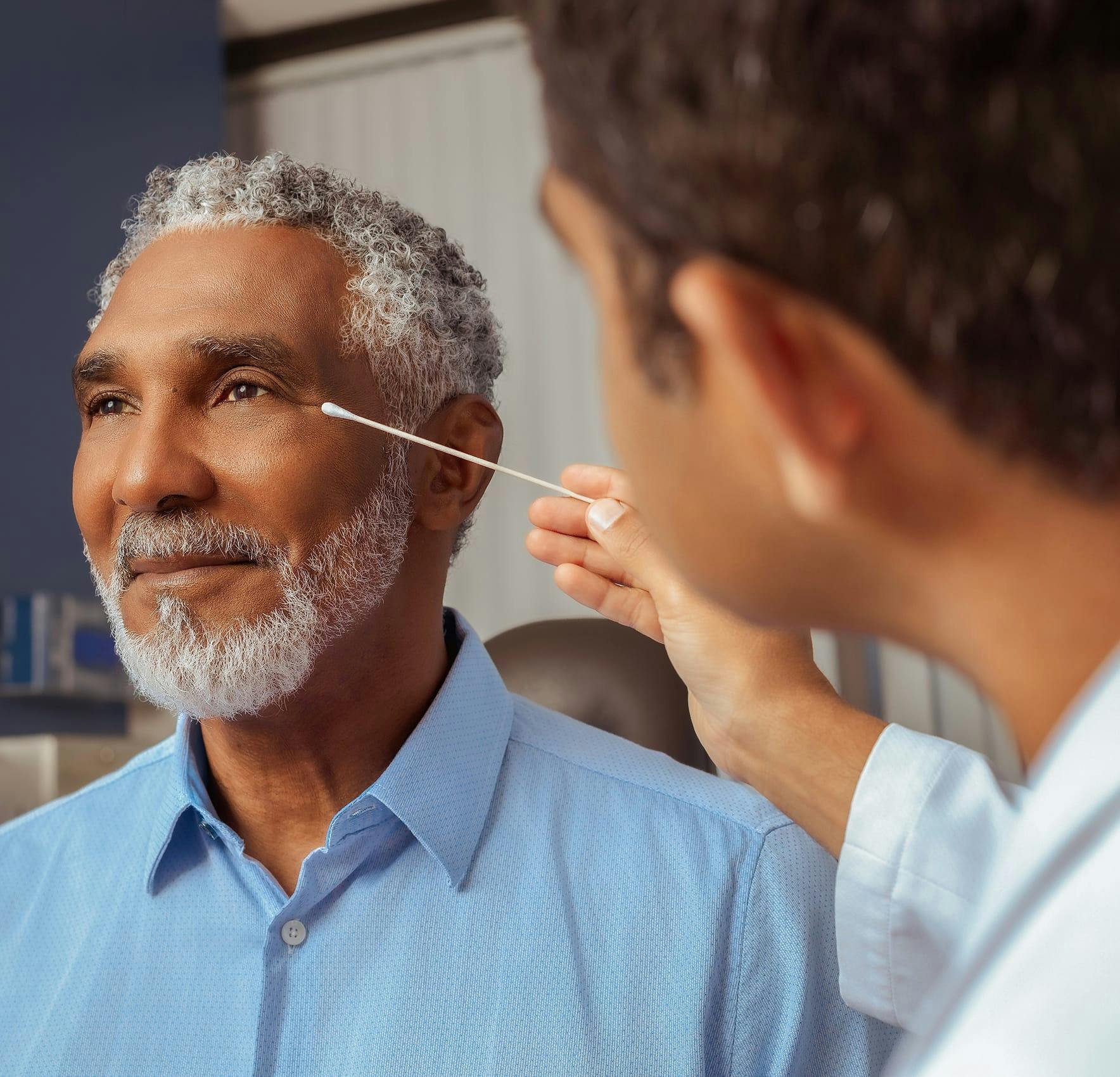 Older man smiling with trimmed gray beard
