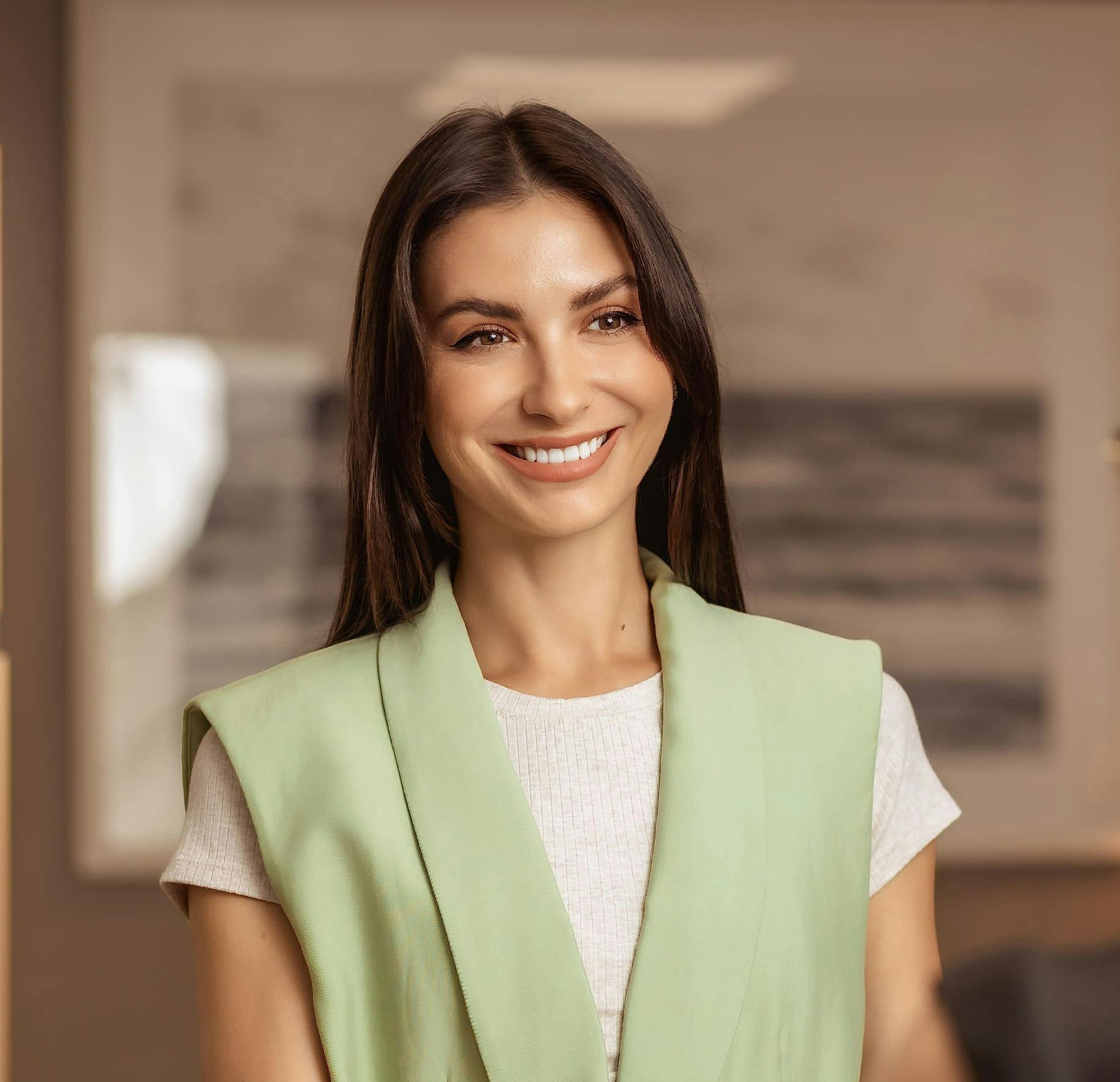 woman smiling in green vest