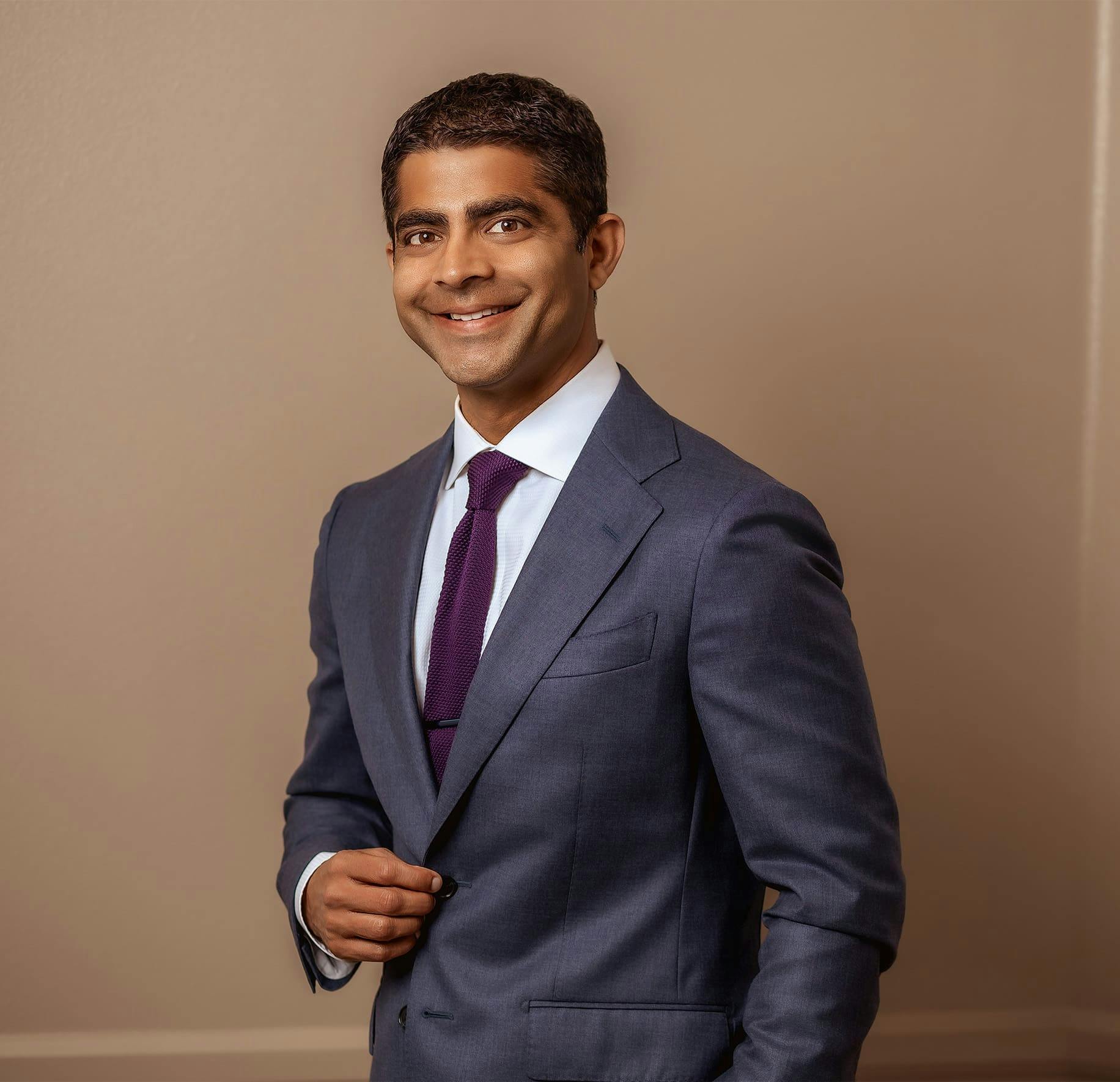 Dr. Iyengar smiling in suit