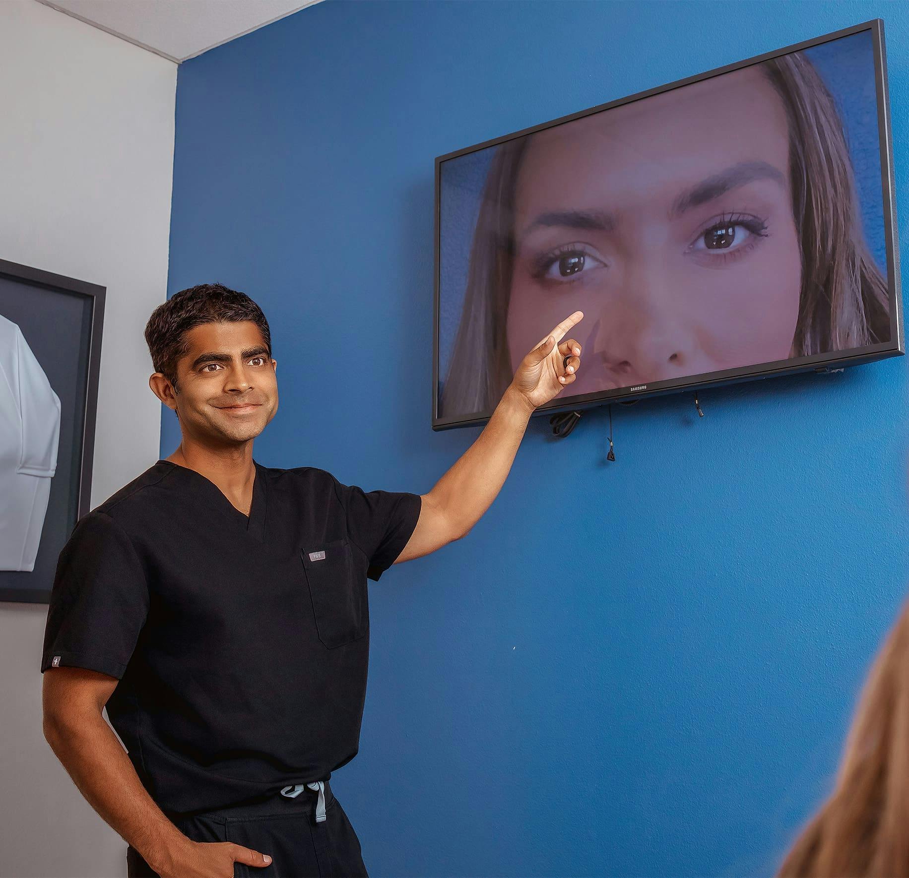 Dr. Iyengar showing patient her eyelids on the TV