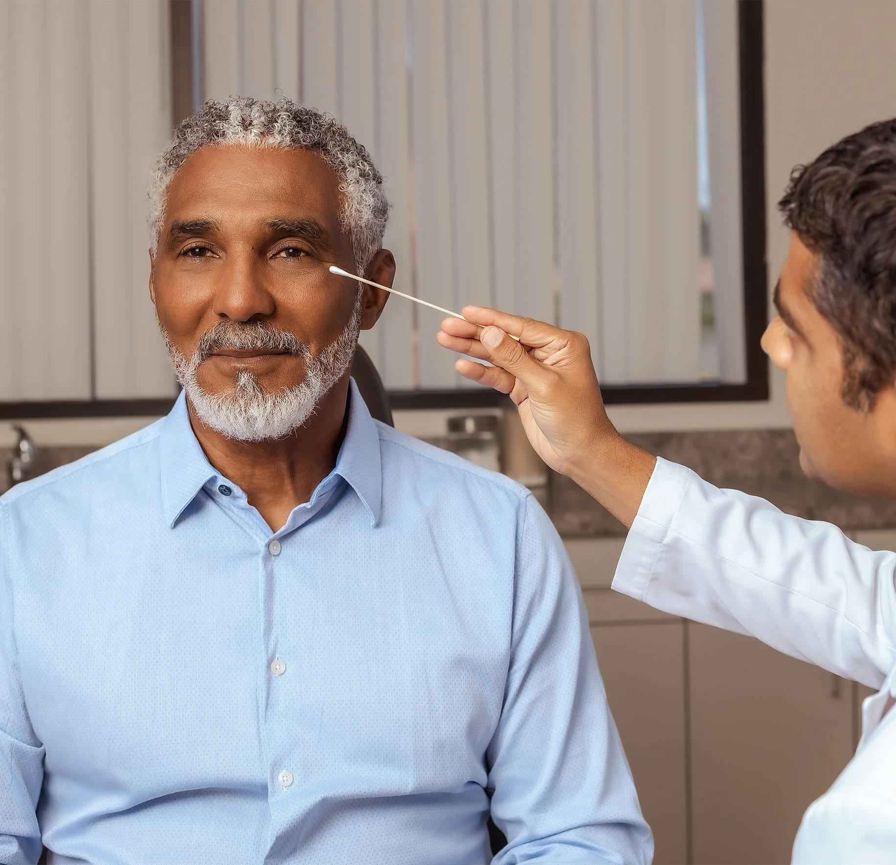 older patient getting eyelids examined by doctor