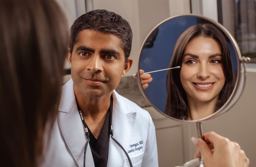 Dr. Iyengar looking at patient while she looking into mirror