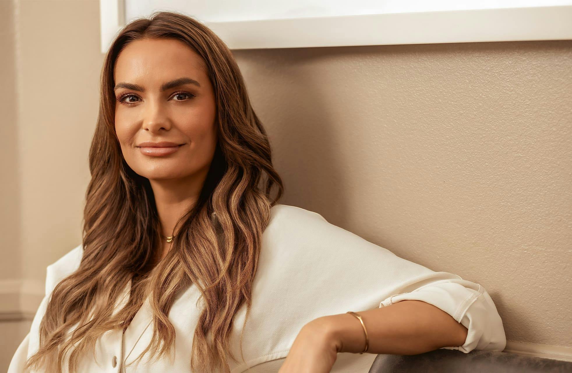 woman sitting down with her arm propped on other chair