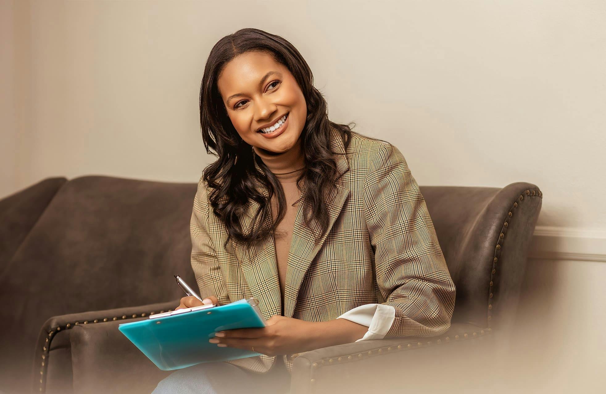 woman smiling while filling out paper work in seat