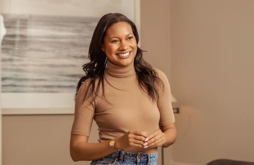 woman smiling with her hands together