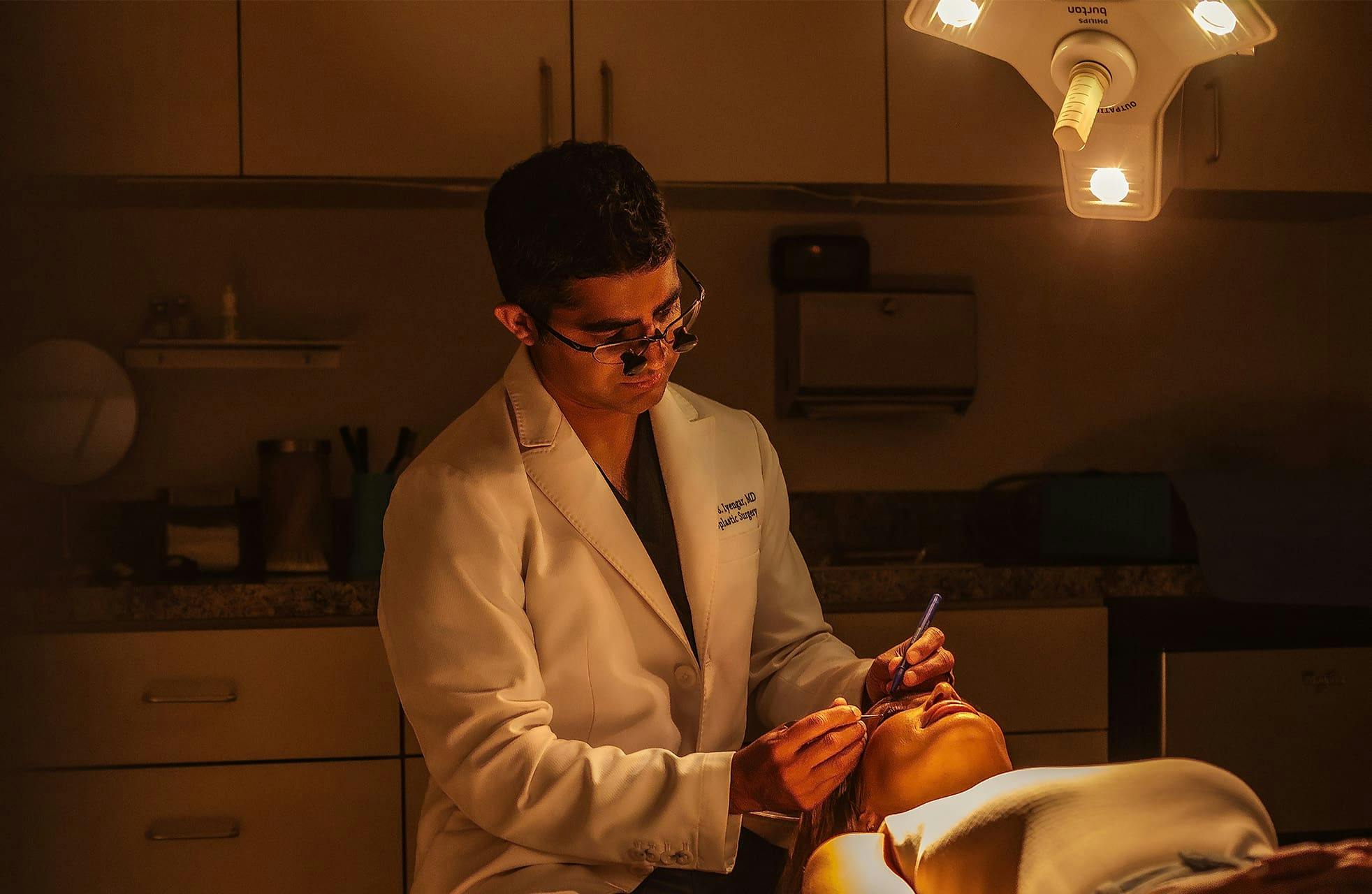 Dr. Iyengar examining patient thats laying in the exam chair