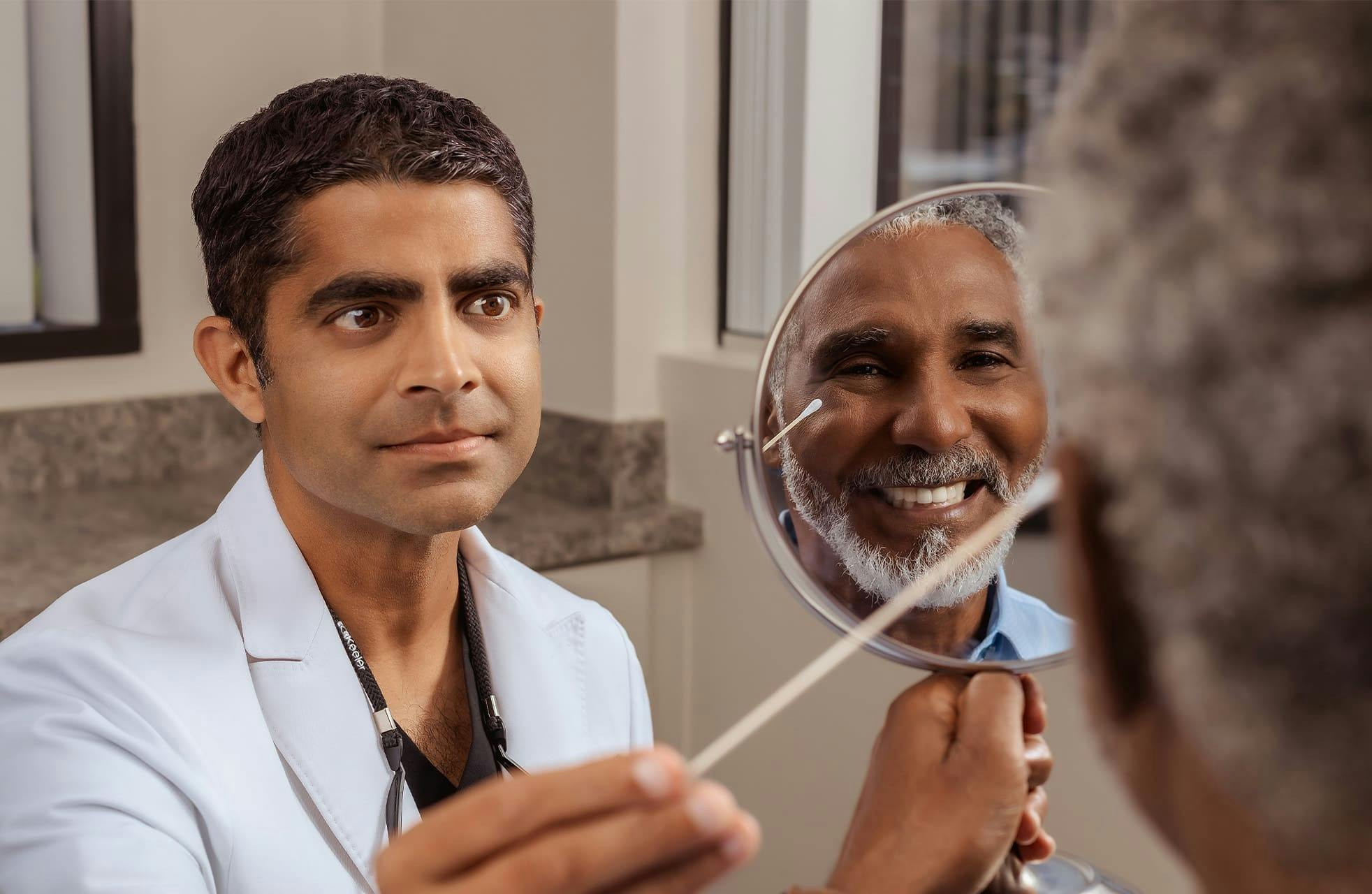 Dr. Iyengar looking at male patient's eyelids