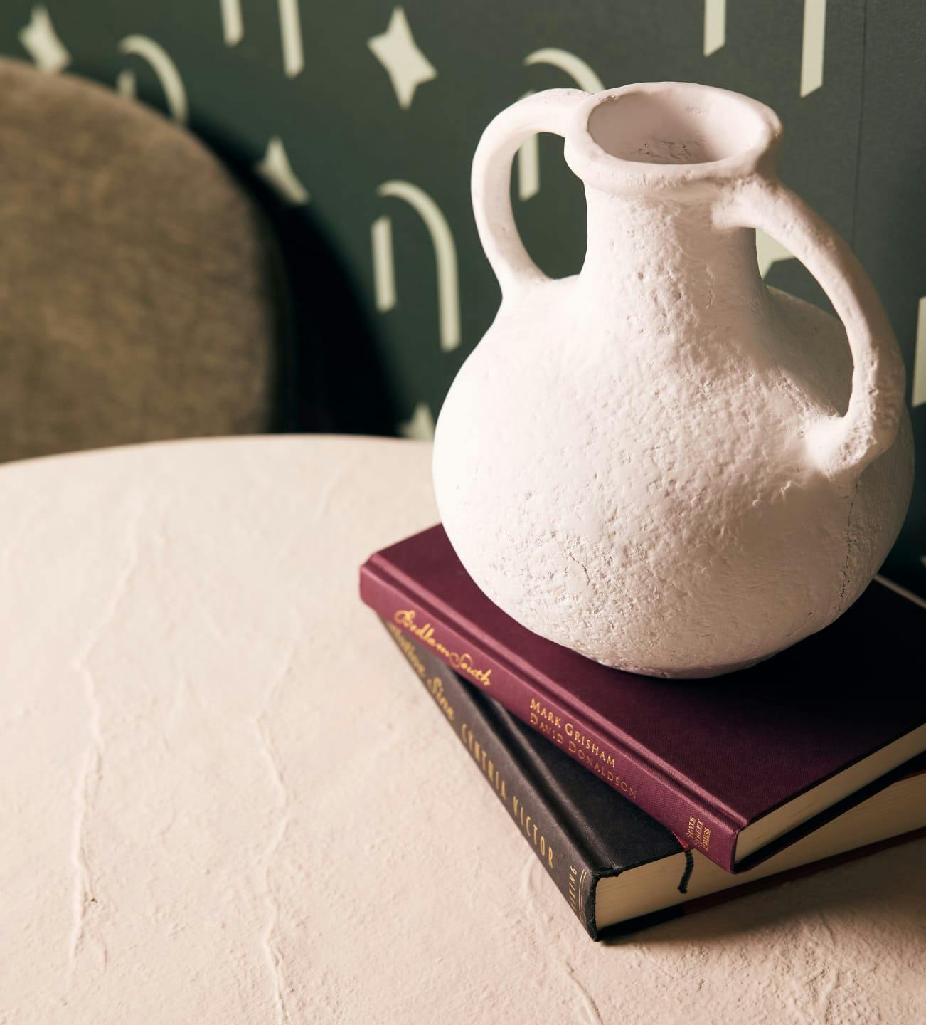 stack of books with a vase on top