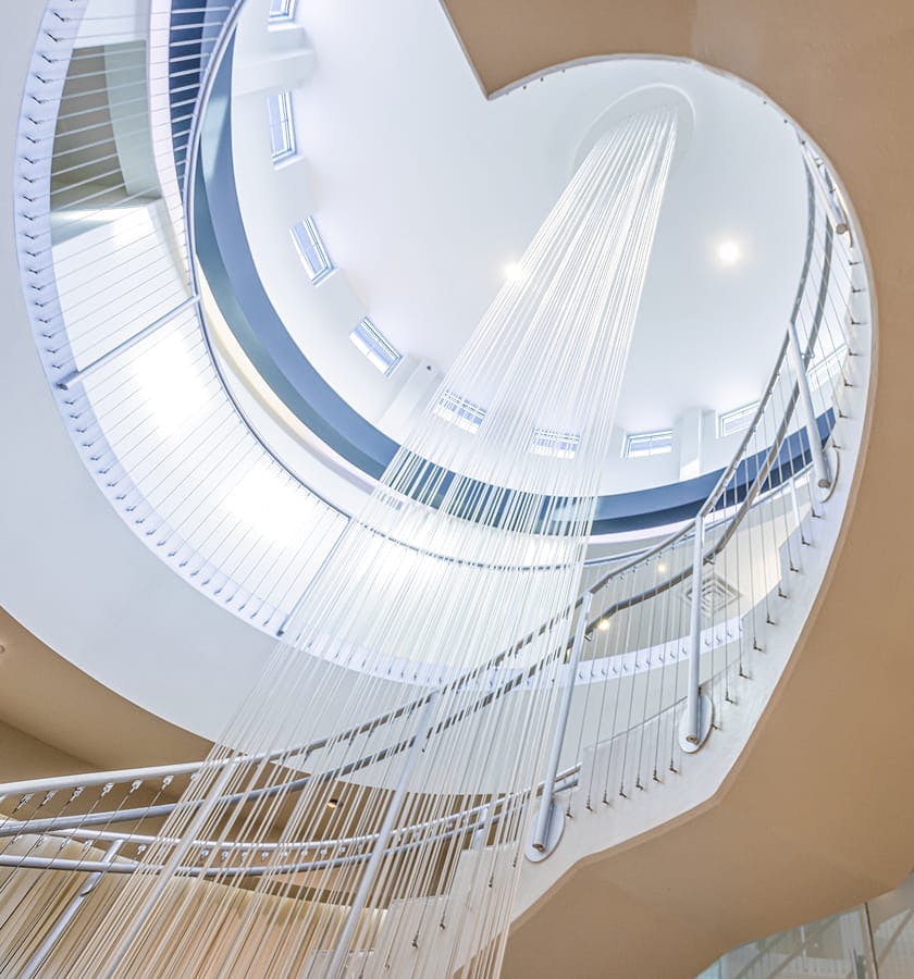 long chandelier in the middle of a spiraling staircase