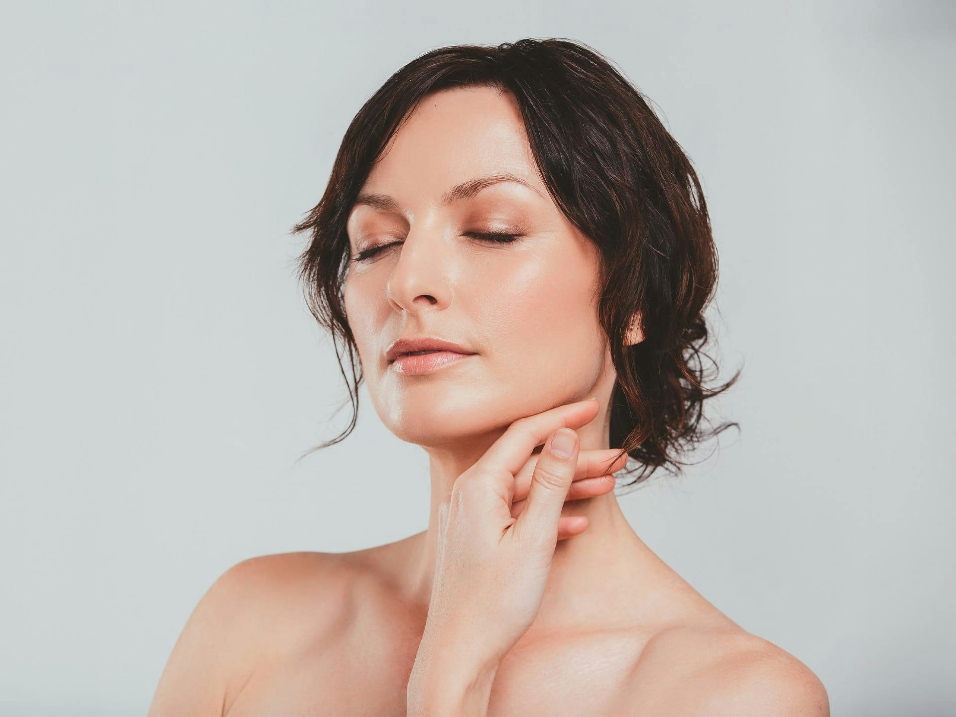 woman touching her neck