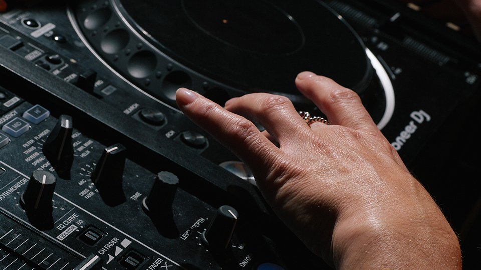 A DJ using a Pioneer CDJ 2000 NXS2 set up for beginners in a Pirate Studios DJ room