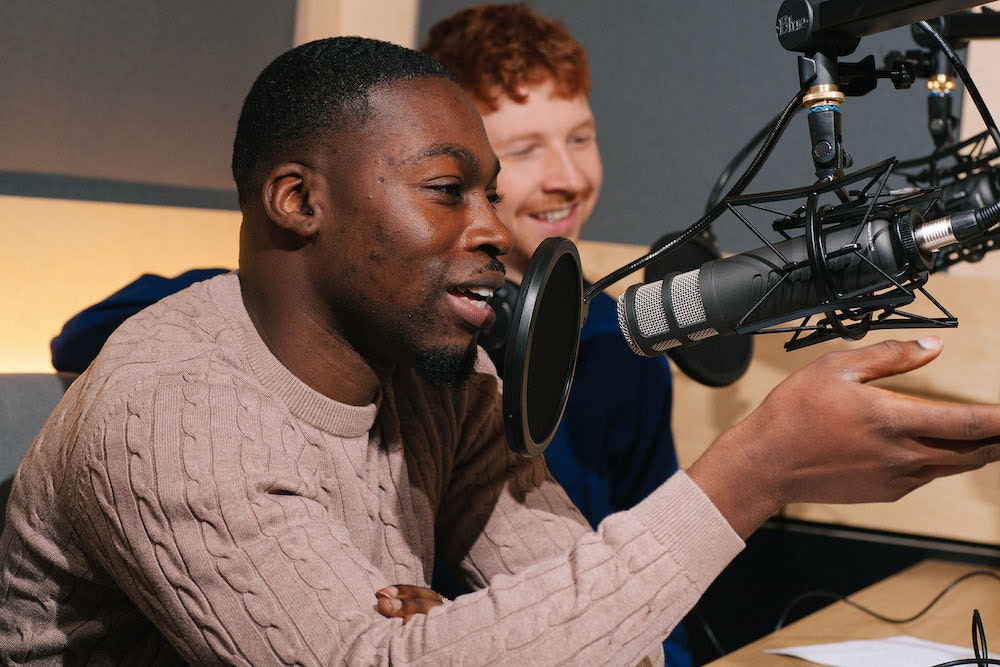 Two people recording with podcast microphones in Pirate Studios Birmingham