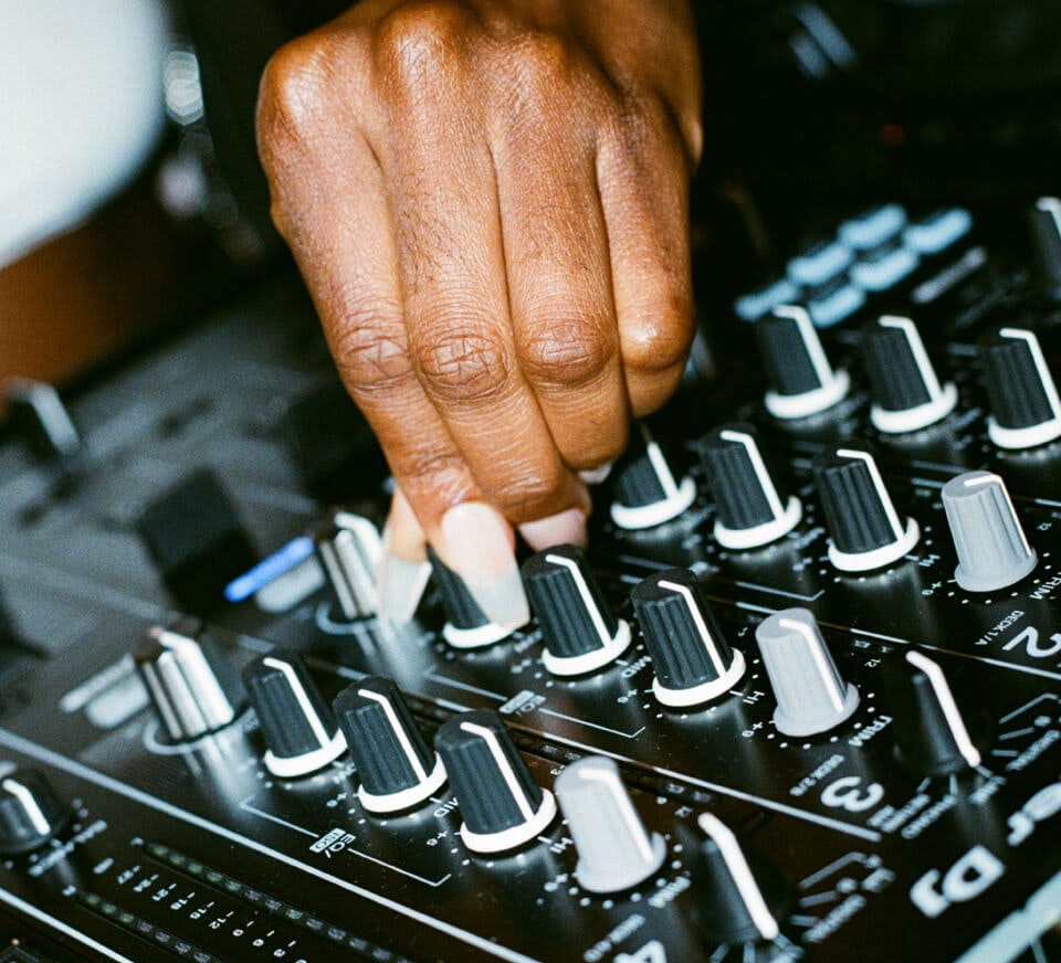 Close up shot of a DJ using a Pioneer DJM-900NXS2 inside a Pirate Studios DJ studio