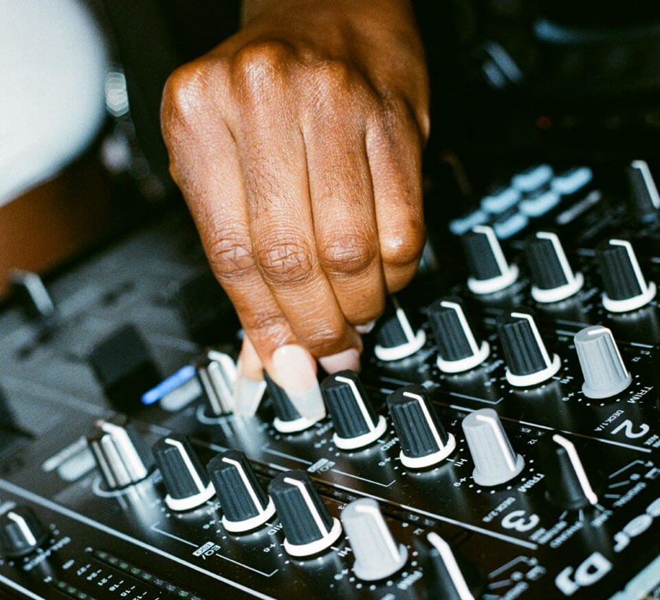 Close up shot of a DJ using a Pioneer DJM-900NXS2 inside a Pirate Studios DJ studio