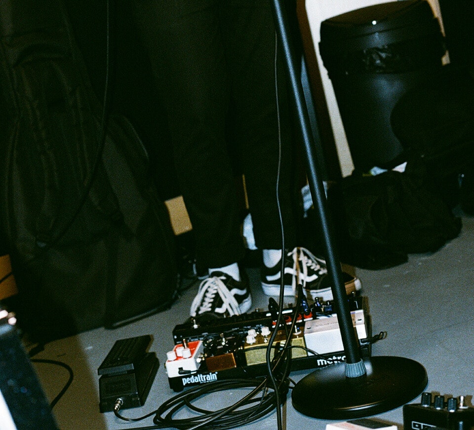 Close up shot of a guitarist and pedal board inside a Pirate Studios rehearsal studio