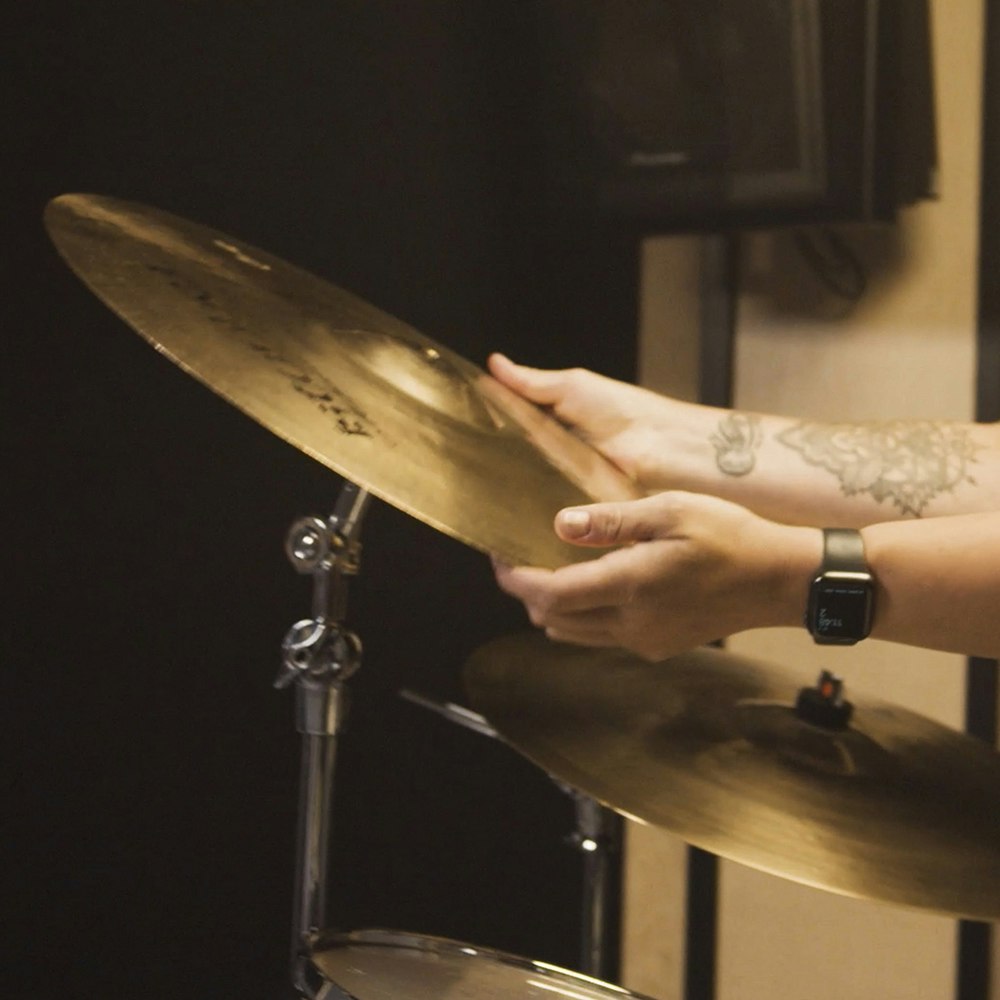 Drummer holding a cymbal from a drum set