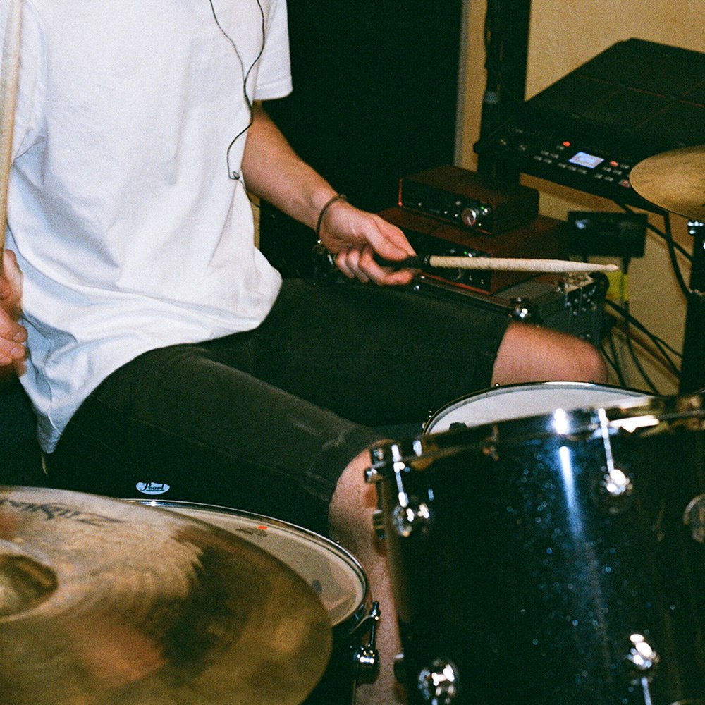 Drummer sitting and playing drums