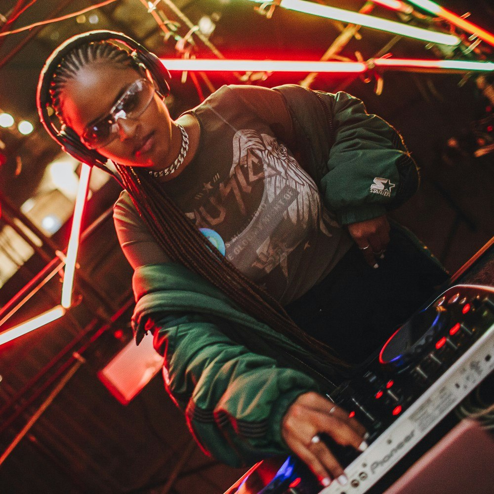 This image may contain: dj, person, human, sunglasses, accessories, accessory, light