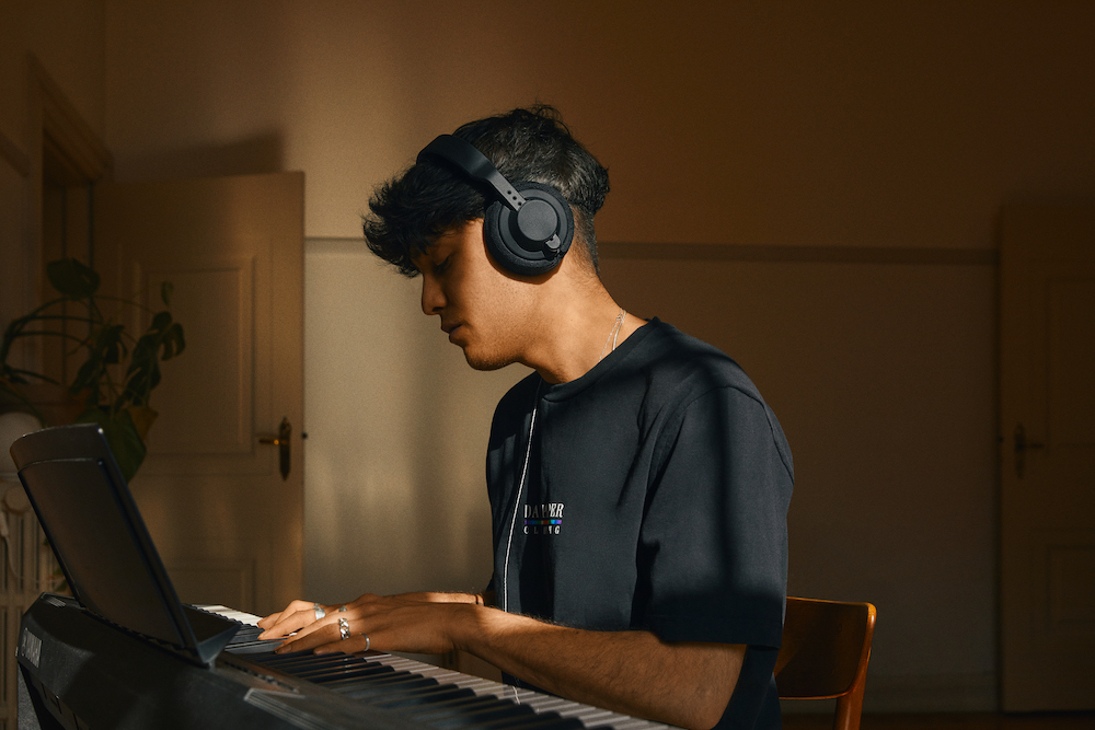 Musician playing keyboard using AIAIAI headphones