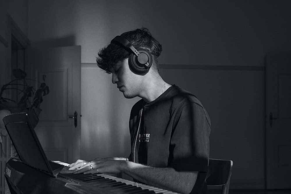 Musician playing keyboard using AIAIAI headphones