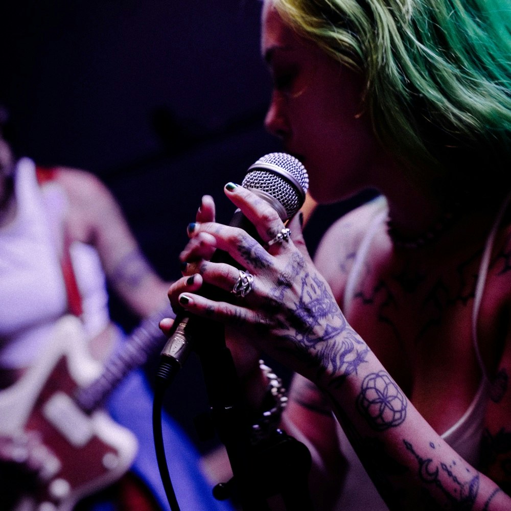 Two women performing on guitar and singing