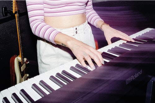 Woman playing the keyboard. Learn to play piano and keyboard.