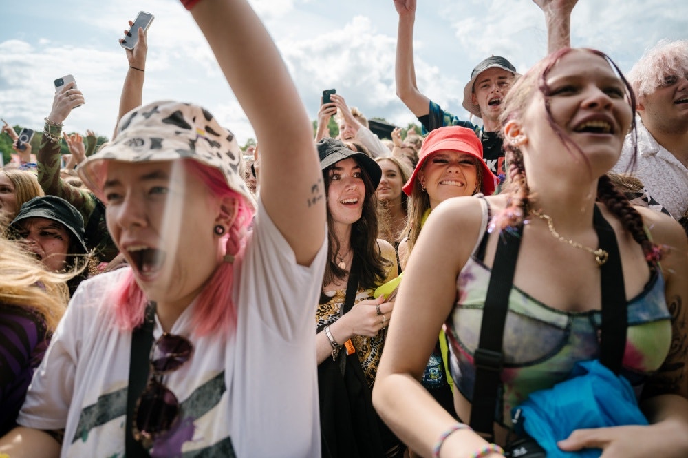 This image may contain: adult, female, person, woman, head, face, hat, people, necklace, celebrating